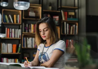 girl sitting table writing