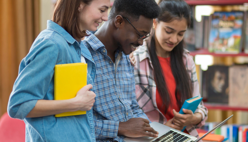 students gathered around a laptop